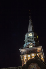 Close up on the clock tower of the Subotica City Hall, in Serbia, at night, lit. Also called...