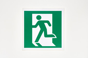 The sign of the direction to the evacuation exit on the wall in the shopping center