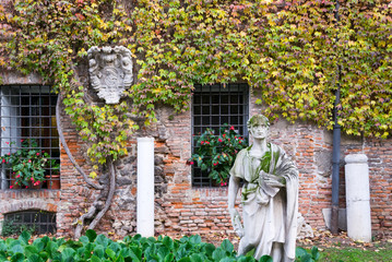 Fototapeta na wymiar Vicenza Italy, view of a beautiful garden closed to the entrance of the Oympic theater. A wonderful place decorated with statue and art seen in autumn colors