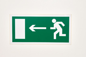 The sign of the direction to the evacuation exit on the wall in the shopping center