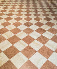 Marble pavement in an italian palace in Italy. White and red shiny stones build upa nice rhombus texture seen in perspective
