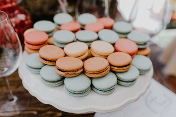 A lot of colorful macaroons on a tray at a party.