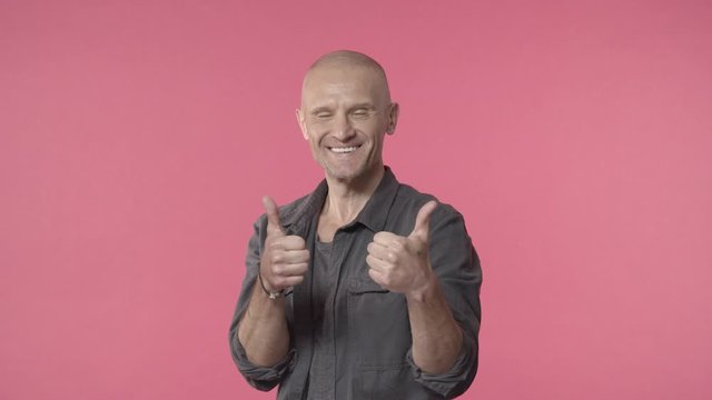 Middle-aged cheerful, handsome man with grey beard and bald, jumping from bottom with thumbs-up, recommend great product, guarantee best quality, agree and approve, like something, give permition