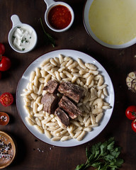 Dagestani twisted hinkal with meat on a plate, top view