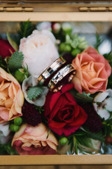 Wedding rings close-up on flowers.