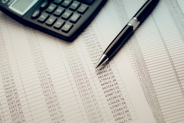 black pen on a sheet of paper with numbers and calculate