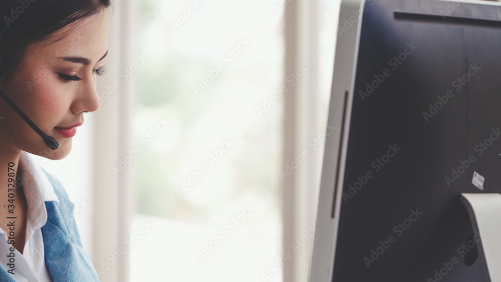 Poster customer support agent or call center with headset works on desktop computer while supporting the cu