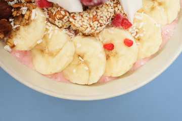Handmade Bowl healthy tasty breakfast of yogurt, smoothie with granola, nuts, bananas and berries