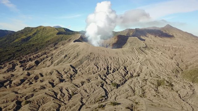 Smoke erupting from Mount Bromo, Java, Indonesia, Flying towards volcano