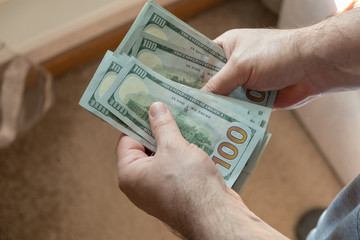 Men's hands keep counting cash us dollars. World crisis concept.