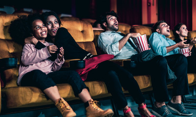 Shocked audience watching a horror movie in the cinema