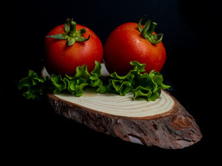 tomate rojo con hoja verde en fondo negro