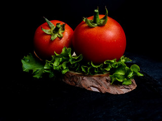 tomate rojo con hoja verde en fondo negro