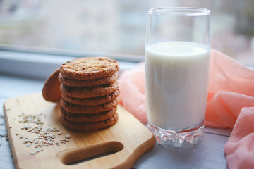 Oatmeal chocolate chip cookies with cinnamon and a glass of milk. Cookies on a wooden cutting board.