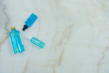 Three types packaging of Blue Ethyl alcohol , spray bottle, plastic bottle and gel bottle, for coronavirus protection  on the marble desk.