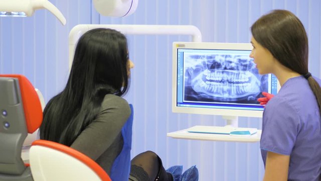 Female dentist shows on the monitor the healthy teeth of the patient