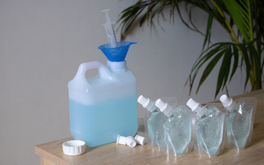 Add alcohol gel from the gallon bucket to the alcohol gel sachet bag. On the table and the white...
