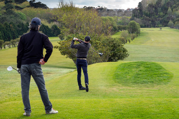 golfistas jugando al golf en un campo de golf ó grupo de amigos jugando al golf