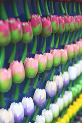 Colorful miniature tulips, wooden flower magnets. Typical Dutch souvenirs for tourists in a shop from Amsterdam, Netherlands. Typical Amsterdam symbol. Selective focus. 