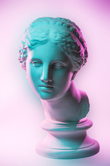 Statue of Venus de Milo. Creative concept colorful neon image with ancient greek sculpture Venus or Aphrodite head. Webpunk, vaporwave and surreal art style. Pink and green duotone effects. © Ded Pixto