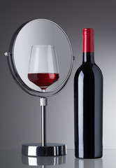 ein Gals und eine Flasche mit Rotwein 