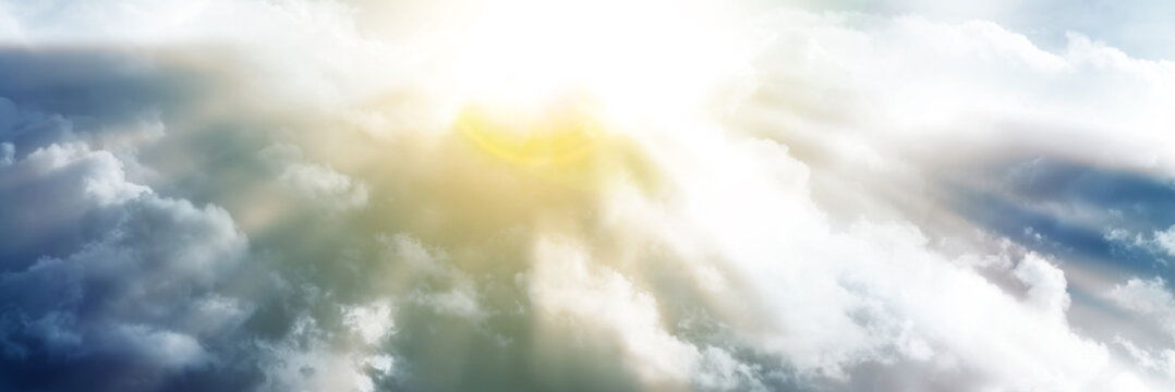 The sun's rays of light break through the clouds. Beautiful background of meditation. Panoramic image.