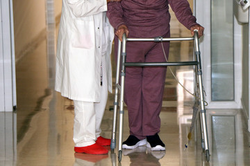 Physiotherapist working with an elderly patient doing mobility exercises