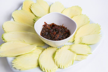 sliced mango with sweet fish sauce serve in white plate 