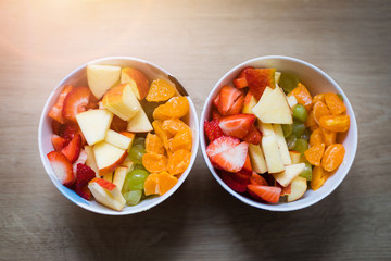 Fruit bowl: Strawberries, apple chunks, grapes and tangerines in a bowl