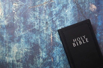 A Holy Bible Closed on a Blue Wooden Table with Copy Space