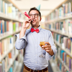 Man wearing a red bow tie and party hat. Holding a champagne glass.