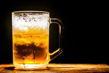 Chilled glass of beer on the wooden table 