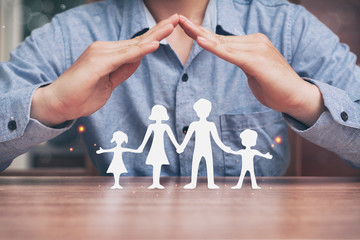 Fototapeta na wymiar Protecting hands over paper family, family Protection and stay home or working at home with care concept.