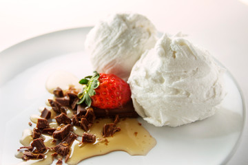 dessert with ice cream balls decorated with strawberries and chocolate on a white background