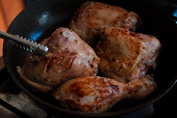 Roasted chicken breast in barbecue sauce in a pan on the kitchen with chicken tongs 