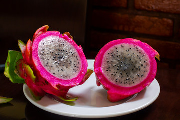 Dragon fruit or pitaya fruit Hylocereus undatus. Sectional view on a wooden background. Tropical,...