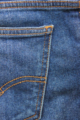 Denim jeans pocket detail, vertical dark blue jeans fabric close up. Modern simple jean fabric, seams pattern on dark blue denim pants background material detail