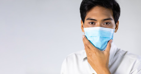 Studio portrait of Asian woman wearing face medical surgical mask, looking at camera, isolated on white background. Mask protection against virus. Covid-19, coronavirus pandemic