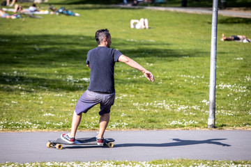 Man riding a skateboard at German park in sunny day