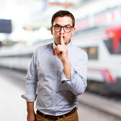 Man wearing a red bow tie. Doing silence gesture.