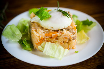 boiled rice with vegetables and fried egg with salad leaves in a plate