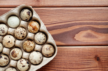 Fototapeta na wymiar Quail eggs in a carton on a wooden background. Healthy food.