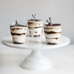 Classic tiramisu dessert in a glass and cup of coffee on light background. dessert with copy space closeup