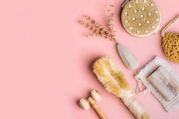 Natural spa and skincare beauty cleansing products with bathroom accessories including natural sponge, pumice stone and exfoliating soap with dry herbs. Flat lay pattern.