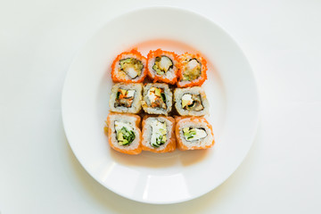 set of sushi and rolls on white plate on white background. delicious japanese traditional food. Fish menu. assorted seafood