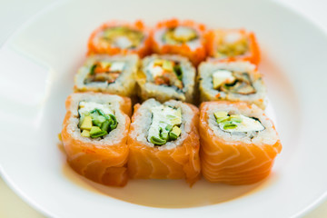 set of sushi and rolls on white plate on white background. delicious japanese traditional food. Fish menu. assorted seafood