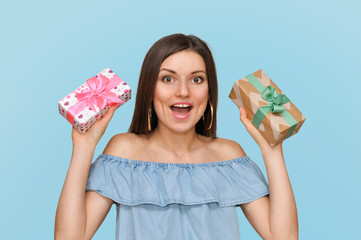 Beautiful sexy woman holds two beautiful gift boxes in her hands.Many gifts, gift choice.