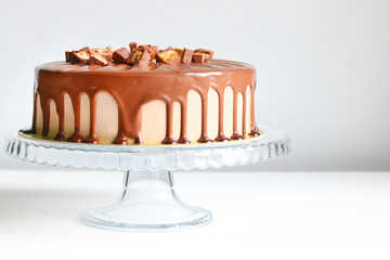 chocolate cake with caramel on light background. snickers cake. dessert with chocolate
