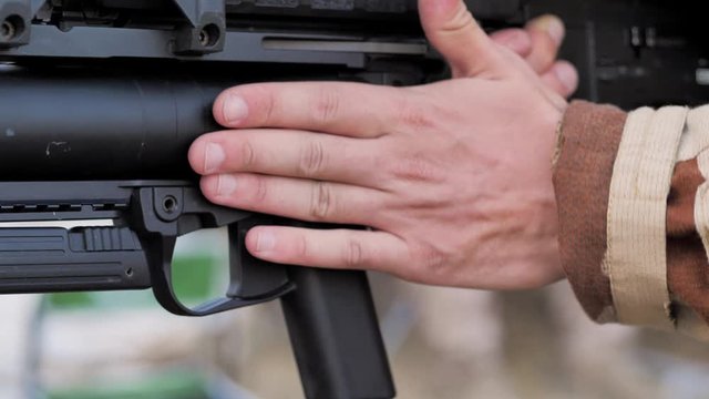 Close-up. Airsoft. Soldier charges hand grenade launcher