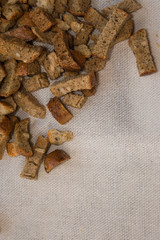 crackers are scattered on a cotton cloth for salad beer snacks with garlic and cereals from rye bread with seeds